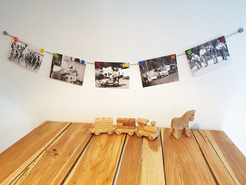 May include: A wooden toy train with three cars and a wooden horse on a wooden table. The train is made of natural wood and has a simple design. The horse is also made of natural wood and has a simple design.