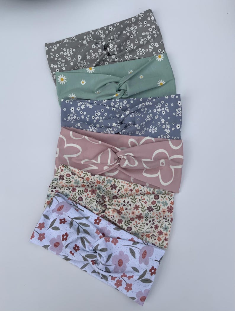 Pu&ograve; includere: Sei fasce per capelli in tessuto con motivi floreali. Le fasce presentano un design a nodo attorcigliato e sono in tonalit&agrave; di grigio, verde, blu, rosa e bianco. Ogni fascia &egrave; decorata con diverse stampe floreali.