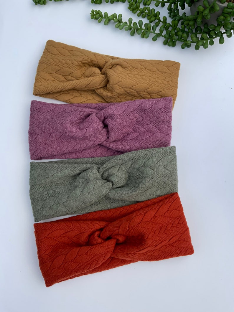 Puede incluir: Cuatro diademas de punto en diferentes colores: amarillo mostaza, malva, verde oliva y naranja &oacute;xido. Las diademas est&aacute;n hechas con un patr&oacute;n de punto de cable y tienen un nudo retorcido en el centro.