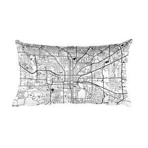 May include: Black and white map of a city printed on a white rectangular pillow. The pillow is a home decor item.