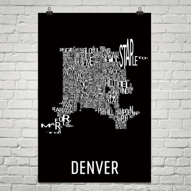 May include: Black poster featuring a white map of Denver, Colorado, composed of neighborhood names. The word "DENVER" is printed in white at the bottom. The poster is hanging on a white brick wall.