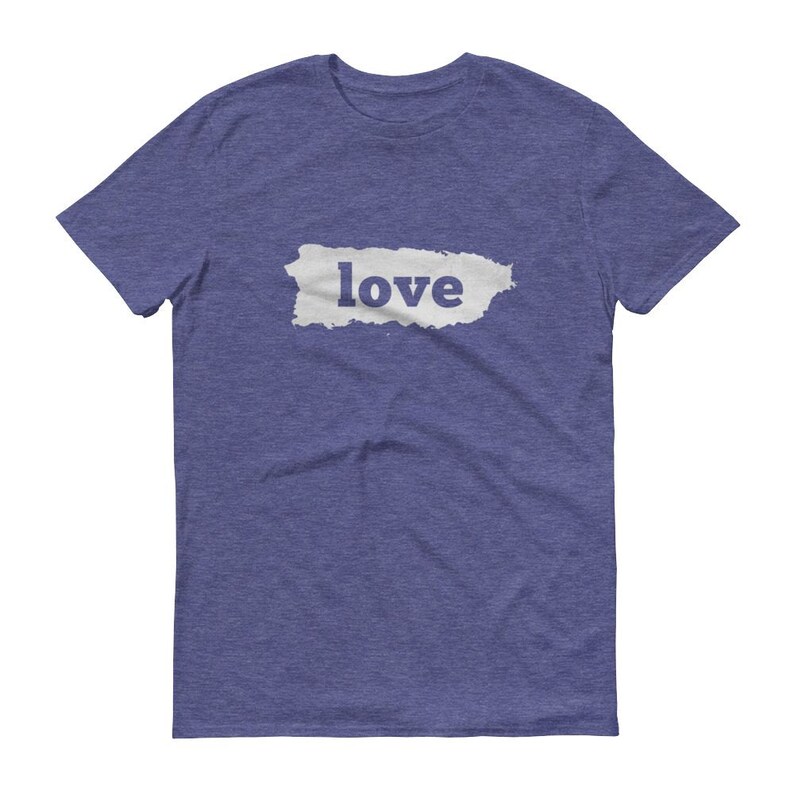Puede incluir: Camiseta azul con la palabra "love" impresa en blanco sobre una forma rectangular gris claro. La camiseta tiene mangas cortas y cuello redondo.