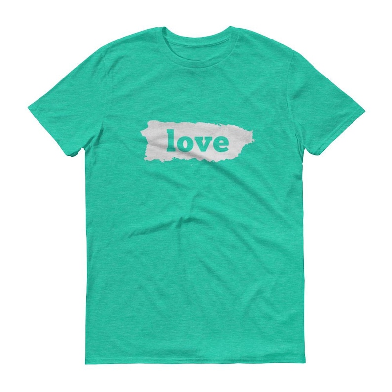 Puede incluir: Una camiseta turquesa con la palabra "love" impresa en letras blancas sobre un rect&aacute;ngulo gris claro texturizado. La camiseta est&aacute; hecha de un material suave y tiene cuello redondo.