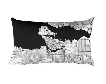 May include: Black and white pillow featuring a map of Vancouver, Canada. The pillow is rectangular and has a black background with white lines outlining the city streets and waterways.