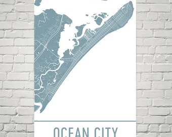 May include: A blue and white map print of Ocean City, Maryland. The map shows the city's streets and waterways. The city name is printed in black at the bottom of the print.