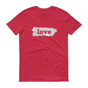 Puede incluir: Camiseta roja con la palabra "love" en un rect&aacute;ngulo blanco. La palabra "love" est&aacute; en fuente roja. La camiseta es de cuello redondo.