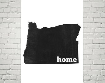 May include: Black and white print of the state of Oregon with the word "home" in white text below the state outline.