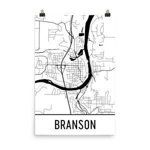 May include: Black and white line art map of Branson, Missouri. The map shows the city's streets and the layout of the city. The word "Branson" is printed in black at the bottom of the map.