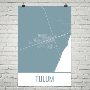 Puede incluir: Un póster con un mapa de Tulum, México, en un color verde azulado apagado. El mapa muestra el diseño de la ciudad con líneas blancas. La palabra "TULUM" está impresa en la parte inferior del póster.