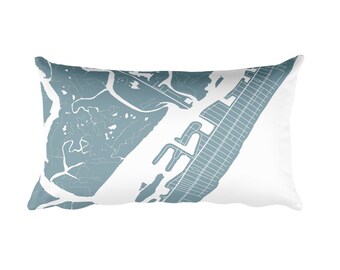 May include: A light blue throw pillow with a map of a city printed on it. The map is in a light blue color and is centered on the pillow.