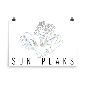 May include: A white poster featuring a detailed map of Sun Peaks ski resort, with trails in green, blue, and red. The words "SUN PEAKS" are printed in a bold, black font at the bottom. The poster is held by two black binder clips.