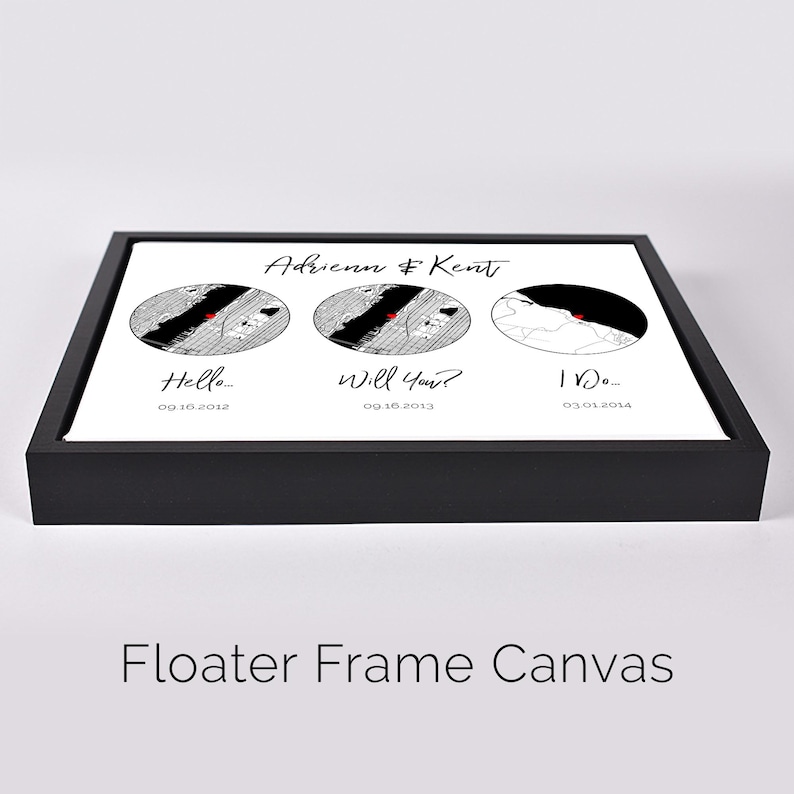 May include: A rectangular canvas in a black floater frame featuring three circular map illustrations with red heart markers. Text reads Adrienn & Kent, Hello 09.16.2012, Will You? 09.16.2013, and I Do 03.01.2014. The design is printed on a white background.