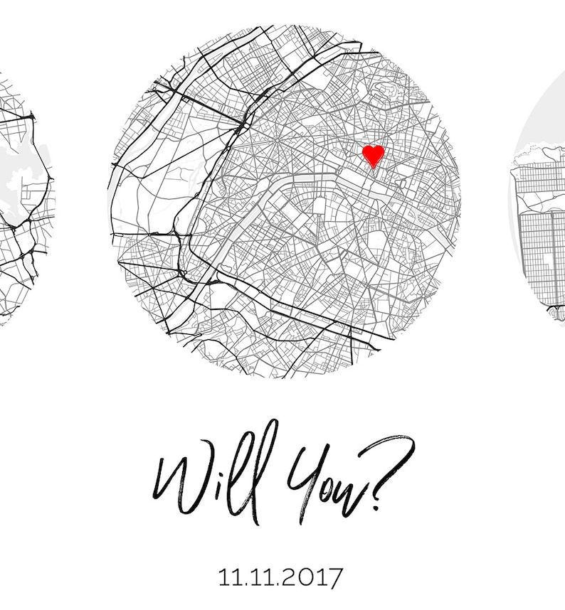 May include: A circular black and white street map print featuring a red heart icon placed over a specific location. Below the map, the text reads Will You? followed by the date 11.11.2017 in a simple black font on a plain white background.
