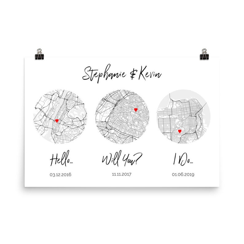 May include: A white rectangular print featuring the names Stephanie & Kevin at the top. Below are three circular black and white city maps, each marked with a small red heart. Text below the maps reads Hello... 03.12.2016, Will You? 11.11.2017, and I Do... 01.06.2019.