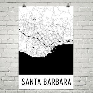 May include: A black and white map of Santa Barbara, California, with the city's streets and coastline detailed. The city name is printed in a bold, sans-serif font at the bottom of the poster. The map is mounted on a white background.