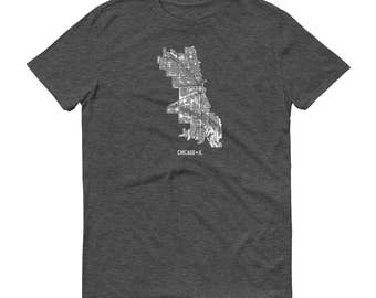 Könnte beinhalten: Dunkelgraues T-Shirt mit einer weißen Grafik der Stadtkarte von Chicago. Die Karte zeigt Straßen und Gebäude. Der Text "CHICAGO - IL" ist darunter in einfacher Schrift gedruckt.