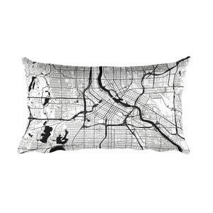 Puede incluir: Cojín rectangular con un diseño de mapa en blanco y negro. El mapa presenta calles detalladas, vías fluviales y parques. El diseño del cojín es una representación detallada de la infraestructura de una ciudad.