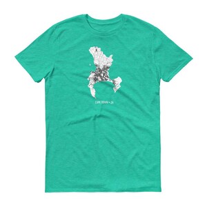 May include: A teal green t-shirt with a white outline of Cape Town, South Africa, and the text "CAPE TOWN - ZA".
