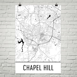 May include: Black and white line art map of Chapel Hill, North Carolina. The map shows the streets and roads of the city. The city name is printed in black at the bottom of the map.