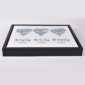May include: A framed print featuring three heart-shaped designs with map details and a red heart. The text reads "The First Day," "The Yes Day," and "The Best Day," with corresponding dates. The frame is black.