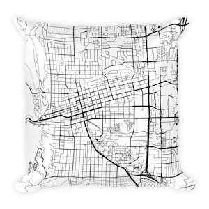 Könnte beinhalten: Schwarz-weiß-Linienkunstkarte einer Stadt auf einem weißen Kissen. Die Karte zeigt Straßen, Wege und andere Merkmale der Stadt.