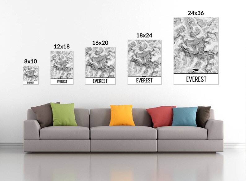 May include: A living room interior with a gray couch and five framed prints of a black and white topographic map of Mount Everest. The prints are in various sizes, including 8x10 inches, 12x18 inches, 16x20 inches, 18x24 inches, and 24x36 inches. Each print has the word "EVEREST" printed below the map.