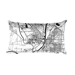May include: A rectangular pillow featuring a black and white map design. The map depicts roads, waterways, and urban areas with detailed lines. The pillow is white with a black graphic, suitable for home decor.