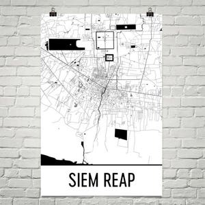 Pode incluir: Um mapa a preto e branco de Siem Reap, Camboja, impresso num poster. O mapa detalha o layout da cidade com estradas, edifícios e pontos de referência. O nome da cidade é impresso em letras pretas a negrito na parte inferior do poster.