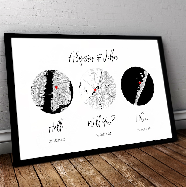 May include: A framed print featuring the names Alyssa & John at the top. Below are three circular map designs, each marked with a small red heart. The text Hello... 01.16.2017, Will You? 07.08.2021, and I Do... 10.14.2022 is printed under each map.