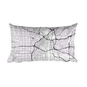 May include: Rectangular pillow featuring a detailed black and white map design. The map shows a network of roads, streets, and geographical features. The pillow is a neutral color, suitable for various decor styles. The pillow's dimensions are approximately 20 inches by 12 inches.