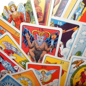 May include: A selection of tarot cards with vibrant illustrations. The cards depict angels, demons, and other symbolic figures. Each card is numbered and has white borders. The overall theme is mystical and spiritual.