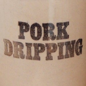 May include: A white ceramic crock with the words "PORK DRIPPING" printed in black.