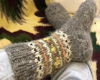 May include: Gray wool socks with a colorful geometric pattern. The socks are knitted with a thick yarn and have a fuzzy texture.