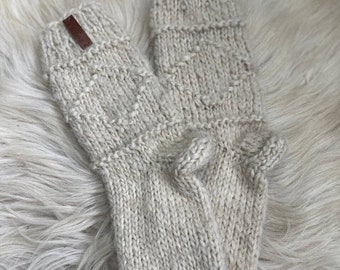 May include: A pair of beige knitted socks with a brown leather tag. The socks are made of a soft, warm material and have a simple, classic design.
