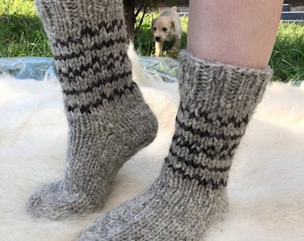 May include: A pair of grey wool socks with brown stripes. The socks are knitted and have a textured appearance.