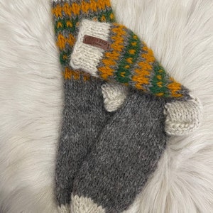 May include: Pair of grey, white, green and yellow wool socks with a brown leather tag that says "SOUVENIR".