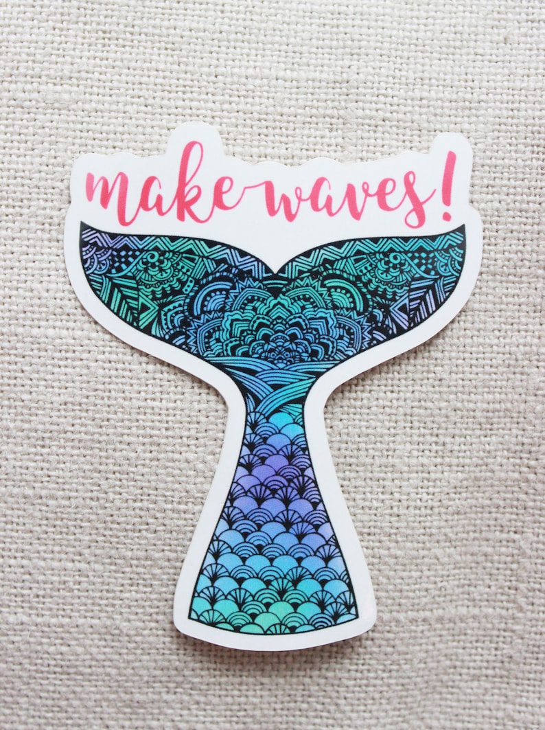Może przedstawiać: Naklejka w kształcie ogona syreny, z szczeg&oacute;łowym wzorem w odcieniach niebieskiego, turkusowego i fioletowego. Fraza "make waves!" jest napisana r&oacute;żowym pismem u g&oacute;ry. Naklejka ma białą obw&oacute;dkę.