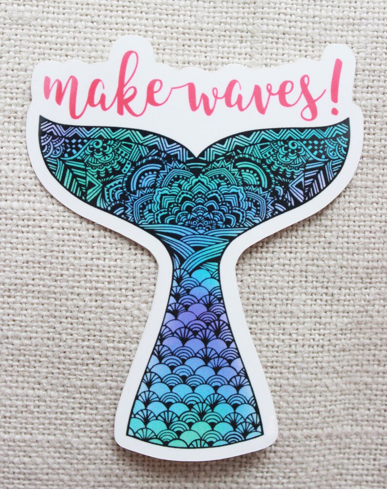 Może przedstawiać: Naklejka z motywem ogona syreny. Ogon ma gradient niebieskiego, turkusowego i fioletowego z misternymi czarnymi wzorami. R&oacute;żowy napis nad nim to "make waves!"