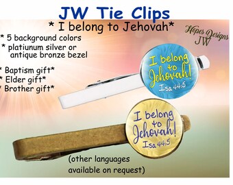 May include: Two tie clips with a gold and silver finish. The tie clips feature a round, colorful design with the text "I belong to Jehovah!" and "Isa 44:5".