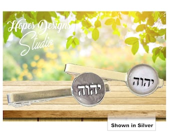 May include: Two silver tie clips with a round, white, and gray design. The design features the Hebrew word "L'dor V'dor" which means "for generations to come".