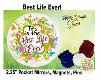 Puede incluir: Un espejo de bolsillo redondo blanco de 2,25 pulgadas con un diseño floral y el texto "This is the 'Best Life Ever!" en letras rojas y verdes. El espejo está rodeado por una bolsa de terciopelo rojo y una bolsa de terciopelo azul.