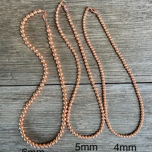 May include: Three rose gold necklaces with different sized beads. The necklaces are 6mm, 5mm, and 4mm in diameter.