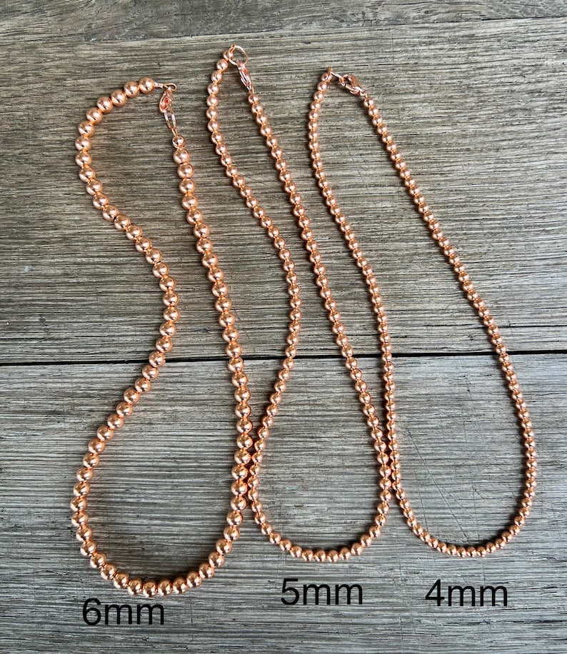 May include: Three rose gold necklaces with different sized beads. The necklaces are 6mm, 5mm, and 4mm in diameter.
