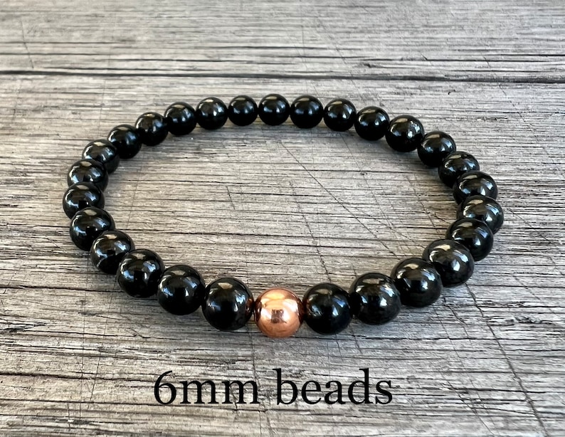 May include: Black beaded bracelet with a single copper bead accent. 6mm beads.