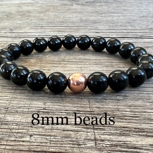 May include: Black beaded bracelet with a single rose gold bead. 8mm beads.