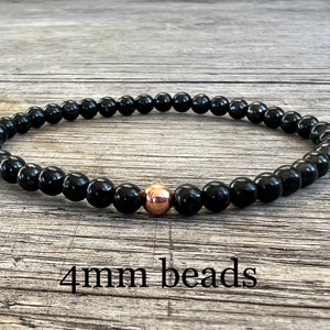 May include: Black beaded bracelet with a single rose gold bead. 4mm beads.