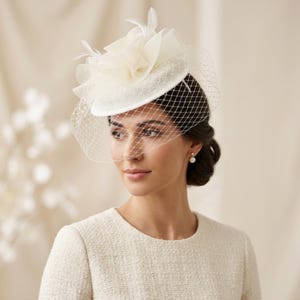 Fascinator ecru, klein hoedje met bloemen en veren.