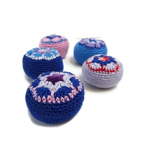 May include: Five crocheted round cushions with different coloured floral patterns. The cushions are made with blue, purple, pink and red yarn.