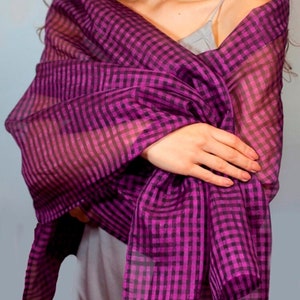 May include: A sheer purple and black gingham scarf. The scarf is folded and draped over a person's shoulders.
