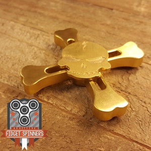 Fidget Spinner in ottone con teschio e ossa incrociate